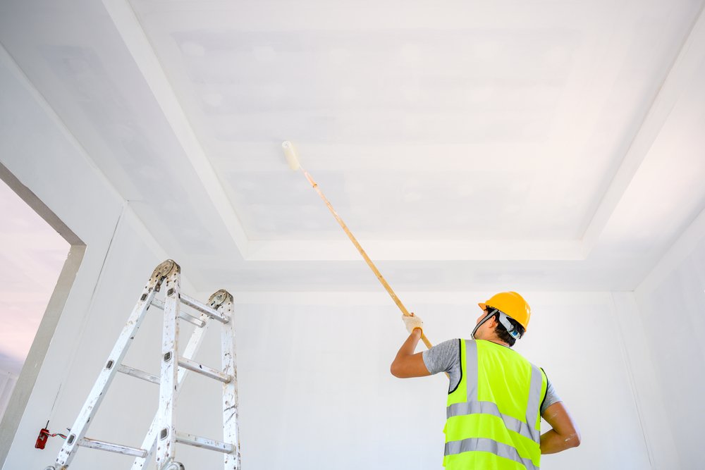 Een illustratie van een glad plafondoppervlak, klaar voor het aanbrengen van renovliesbehang, omringd door gereedschappen voor voorbereiding en reparatie.