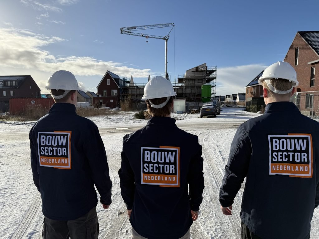 Drie medewerkers van Bouwsector Nederland in bedrijfsjassen bij een nieuwbouwproject